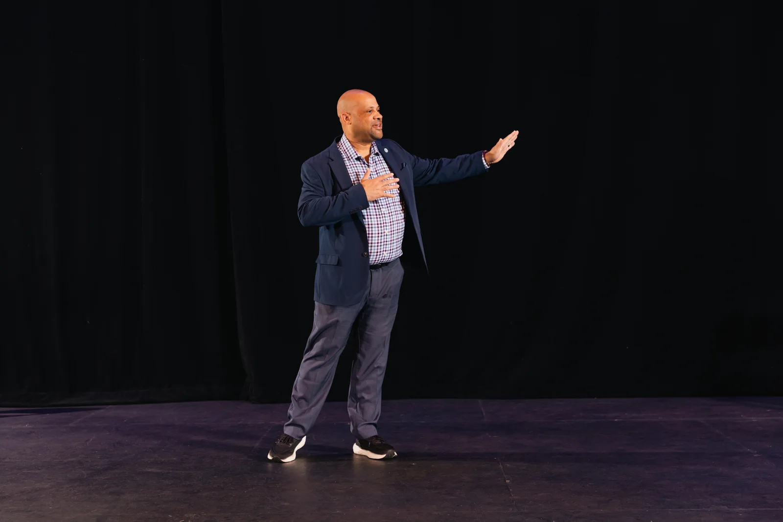 Mike Roberts gesturing while standing on stage